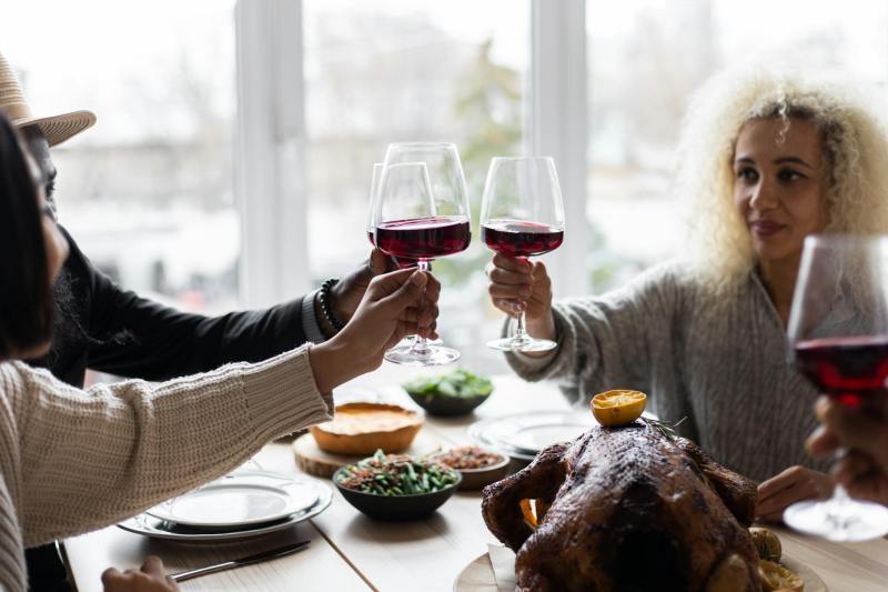 People toasting with wine at Thanksgiving table